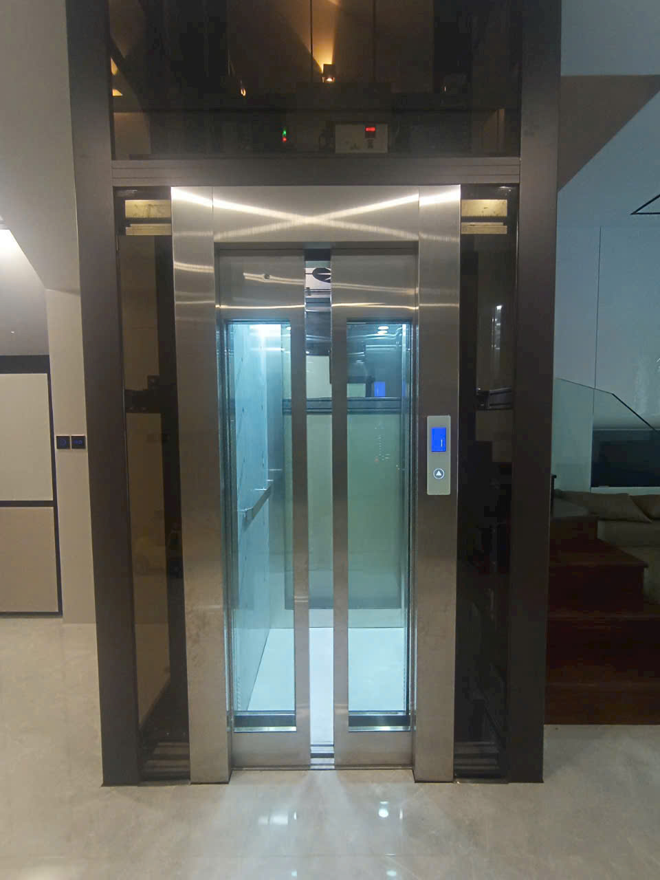 Thang máy gia đình cửa kính khung inox hiện đại lắp đặt trong nhà sang trọng
